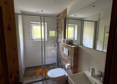 Modernes Badezimmer mit Dusche, Waschbecken und Holzdetails im Alpengasthof Rechtegg.